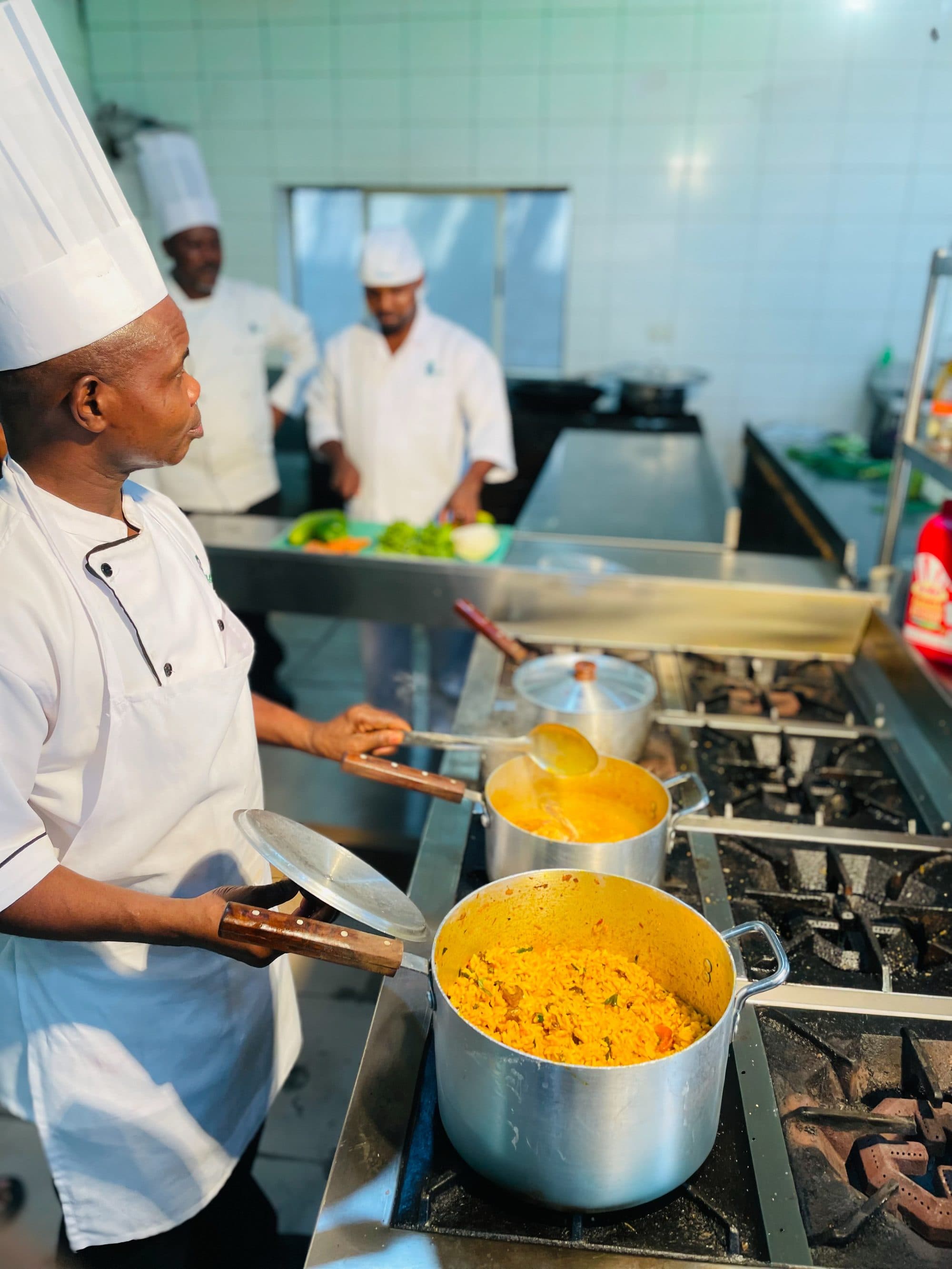 Chef stirring jollof at industrial scale